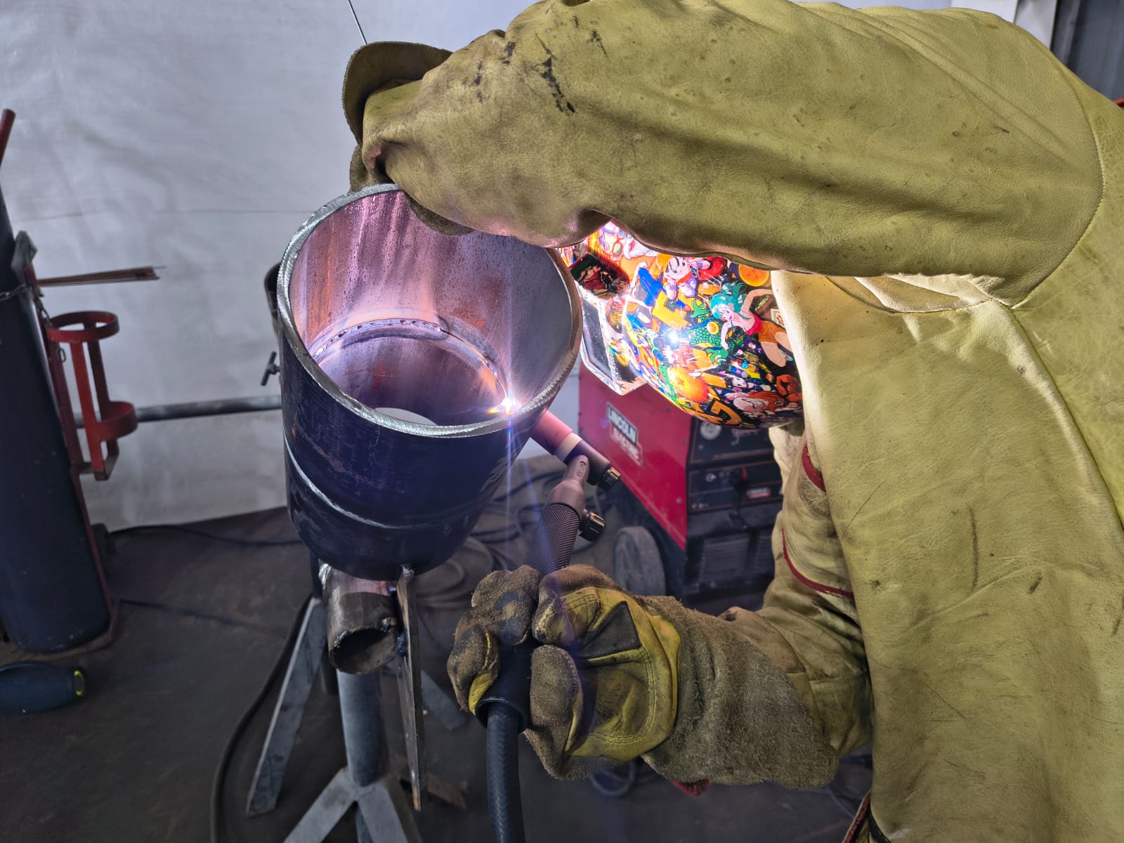 Soldador ejecutando soldadura en probeta de tubería durante prueba de calificación