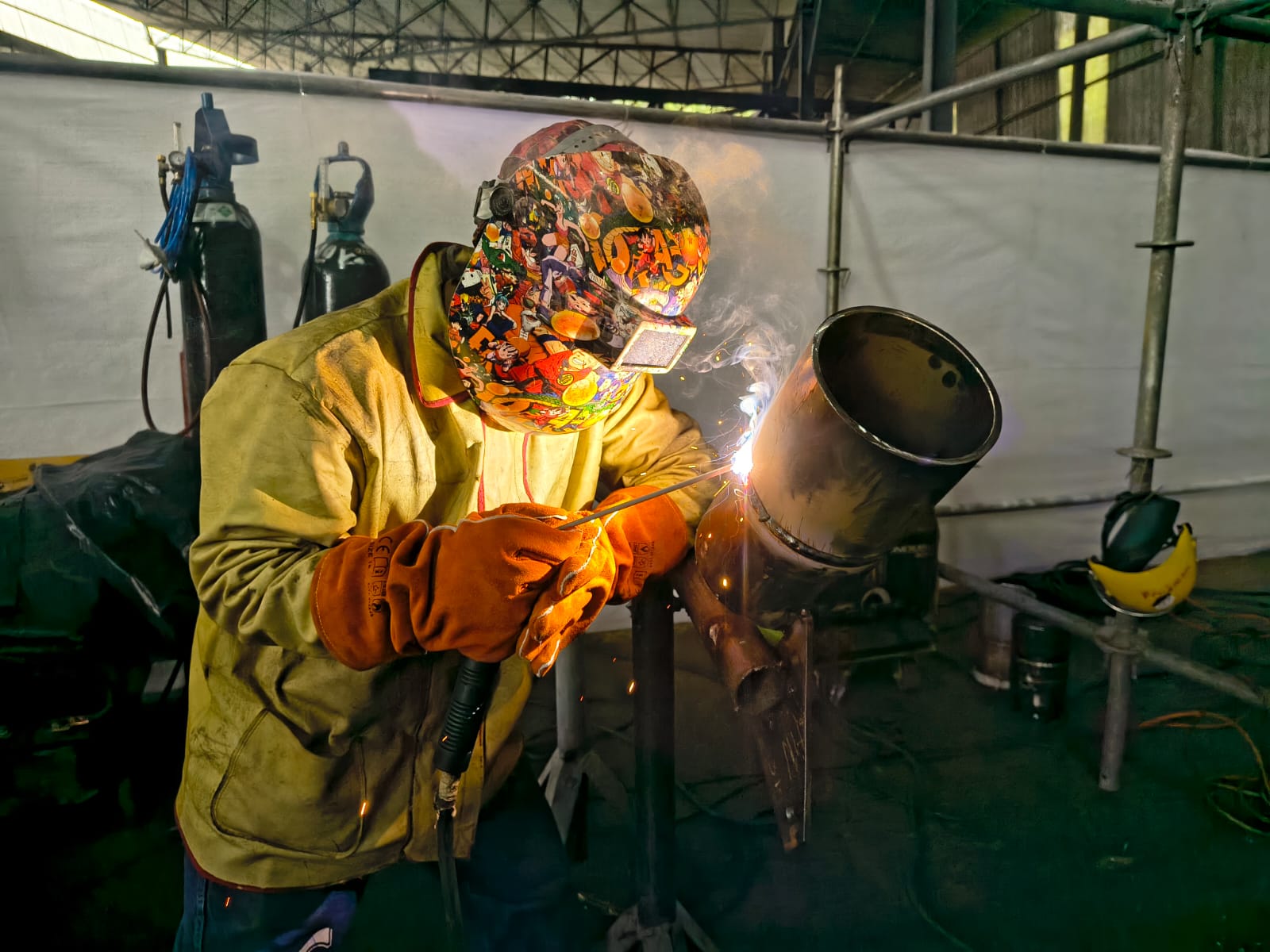 Soldador practicando soldadura de tubería en cabina